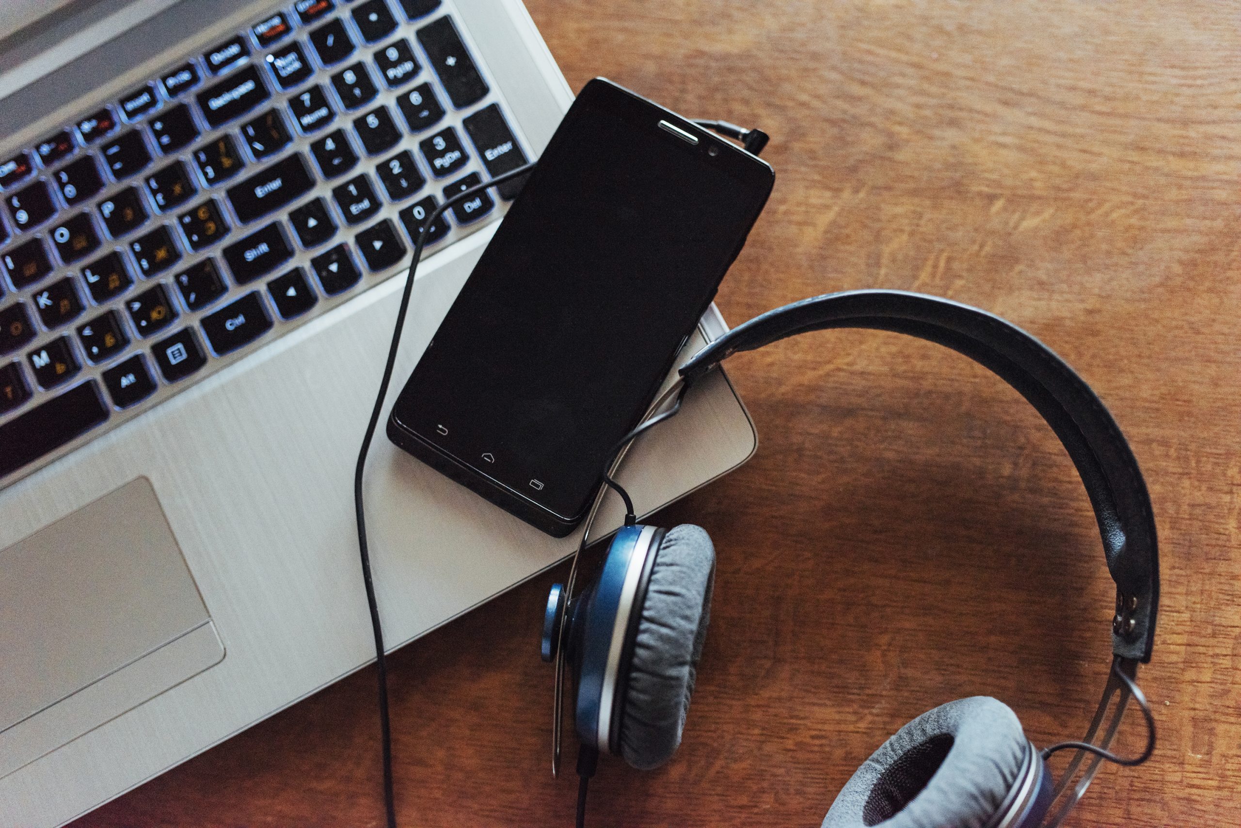 Laptop and headset phone on the table.